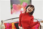 Girl in bedroom, listening to headphone, smiling