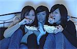 Trois filles dans la chambre, manger le pop-corn, regarder la télévision