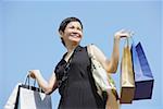 Mature woman carrying shopping bags, looking away