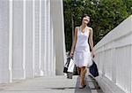 Femme avec des sacs à provisions, marchant le long du pont