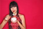 Woman in cheongsam holding bowl of rice