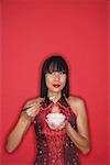 Woman dressed in red, holding bowl of rice