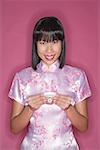 Woman in pink cheongsam, with Chinese tea cup, portrait