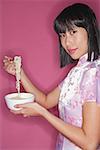 Woman holding bowl of noodles and chopsticks