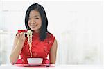 Woman eating bowl of noodles