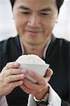 Man holding bowl of rice