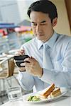 Businessman in cafe, using PDA