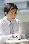 Businessman sitting at outdoor cafe, using laptop