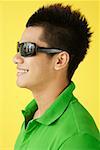 Man in green polo shirt and sunglasses, side view, head shot