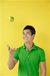 Man tossing green apple