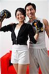 Couple souriant à la caméra, femme avec des gants de boxe