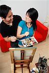 Couple in front of painting easel looking at each other, high angle view