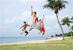 Three men jumping in air, looking at camera