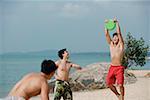 Men on beach playing with Frisbee