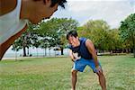 Two men on field, one holding soccer ball