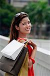Woman carrying shopping bags over shoulder