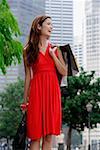 Frau im roten Kleid tragen von Einkaufstaschen, Wegsehen