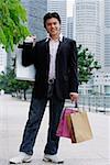 Man standing with shopping bags, smiling at camera