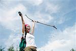 Female hiker, holding hiking stick in air, smiling