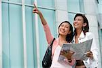 Two women with map, looking up