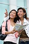 Two young women with map, looking up