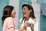 Two women laughing, holding camera