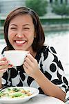 Jeune femme avec une tasse de cappuccino, de mousse sur son nez
