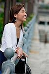Woman leaning on railing, looking away