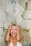 Young woman under shower, smiling