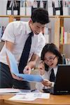 Students in library, looking at folder