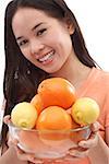 Young woman holding bowl of oranges and lemons