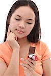 Young woman looking at a bar of chocolate, hand on chin