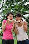 Two women eating ice cream, looking at camera