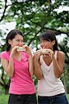 Two women eating ice cream, looking at each other