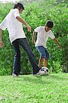 A father and son play soccer together