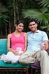 Couple on chairs outdoors, smiling at camera