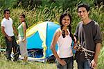 Jeunes amis de camping dans le désert, souriant à la caméra