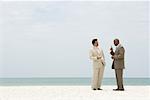 Two businessmen standing face to face at the beach having conversation
