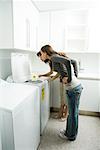 Mother and daughter looking down at daisy growing out of washing machine