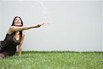 Woman sitting on the ground looking up at bubbles