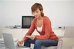 Woman in Living Room with Credit Card and Laptop Computer