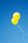 Two Yellow Balloons in Sky