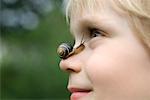 Garçon avec un escargot sur le nez