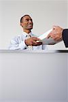 Receptionist Giving Papers to Businessman