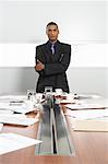 Businessman at Messy Boardroom Table