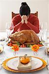 Woman Saying Grace at Thanksgiving Dinner