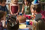 Children blowing out birthday candles