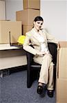 Businesswoman with laptop among boxes