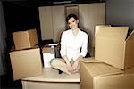 Businesswoman on desk among boxes