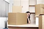 Businesswoman among boxes at desk